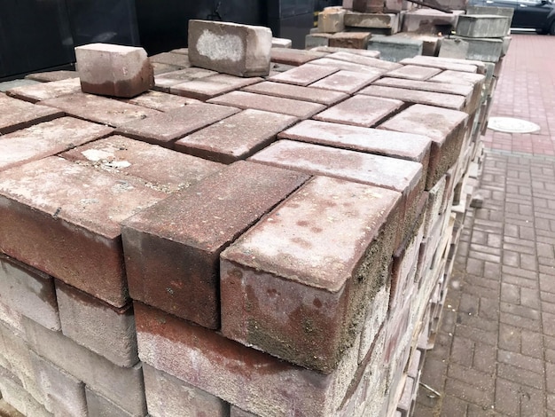 Брусчатка красная цементная плитка для укладки дорожного покрытия на деревянные поддоны на строительной площадке