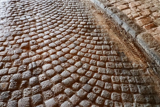 Paving stones a hard road surface a kind of pavement lined with flat rectangular bars of the same shape and size Block stone from which the road surface was built Petrovaradin Novi Sad Serbia