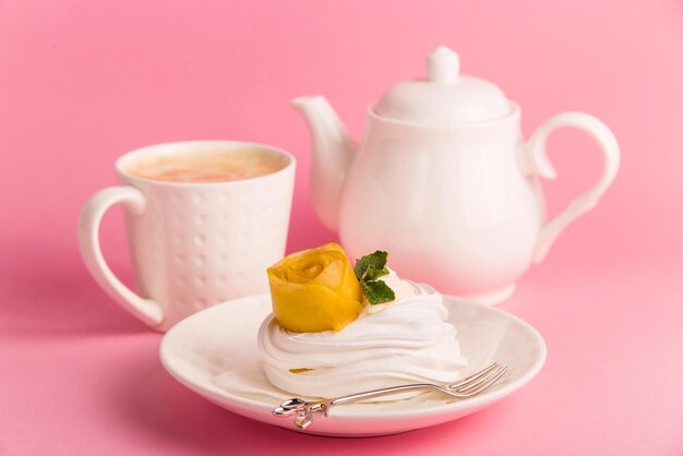 Photo pavlova dessert from meringue with mango rosette on pink background