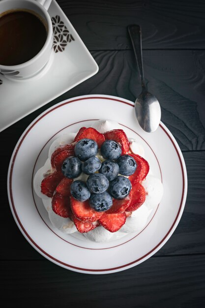 Pavlova dessert op een donkere houten tafel