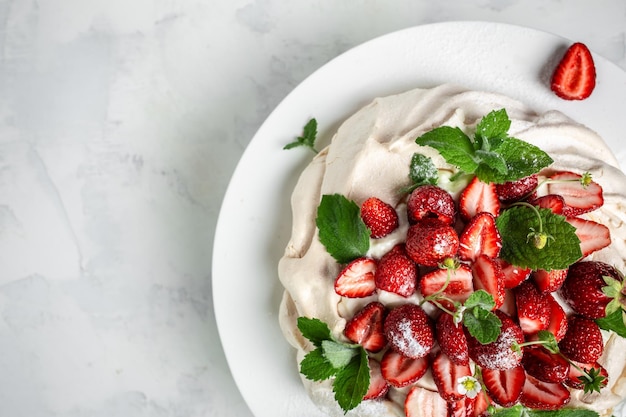 Pavlova meringue cake decorated with fresh strawberries and whipped cream food culinary baking and cooking concept