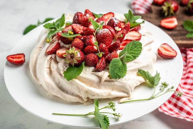 Pavlova meringue cake decorated with fresh strawberries and whipped cream food culinary baking and cooking concept