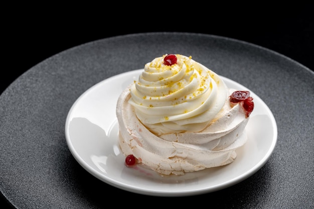 Pavlova meringue cake met verse bessen op zwarte achtergrond Pavlova meringue cake verse bessen