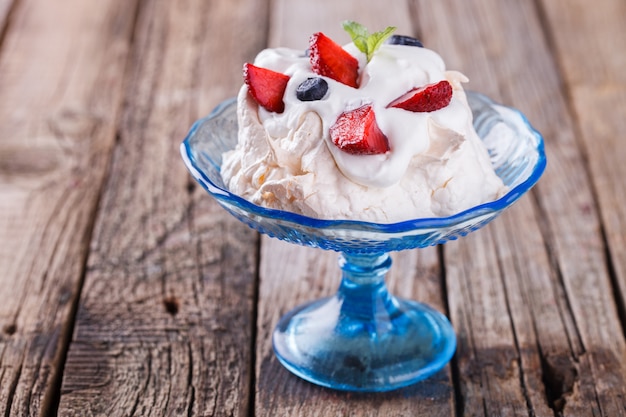 Torta di meringa pavlova con crema e frutti di bosco