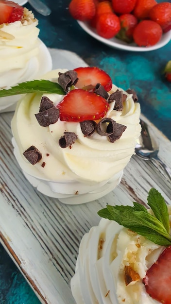 Pavlova meringue cakes with whipped cream and fresh strawberries mint leaves Selective focus