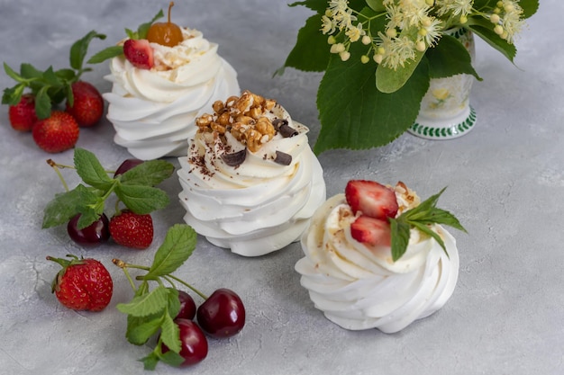 Torte di meringa pavlova con panna montata e fragole fresche foglie di menta messa a fuoco selettiva