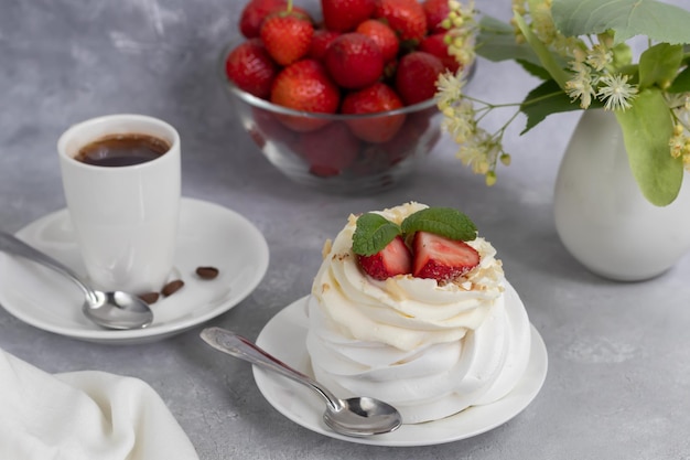 Pavlova meringue cakes with whipped cream and fresh strawberries mint leaves Selective focus