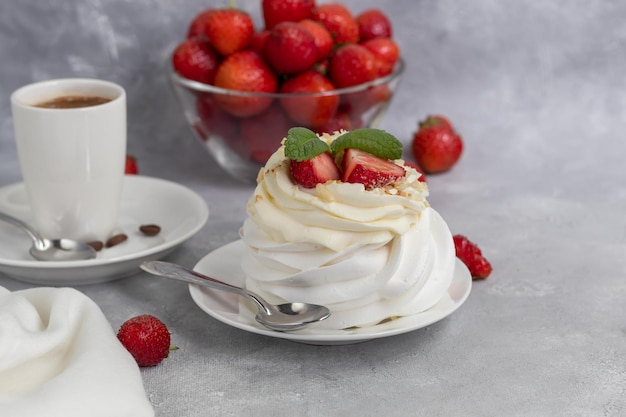 Pavlova meringue cakes with whipped cream and fresh strawberries mint leaves Selective focus