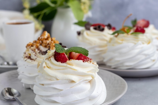 Pavlova meringue cakes with whipped cream and fresh strawberries mint leaves Selective focus