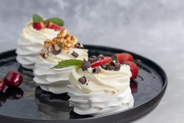 Pavlova meringue cakes with whipped cream and fresh strawberries mint leaves Selective focus