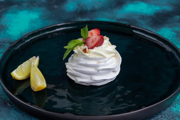 Pavlova meringue cakes with whipped cream and fresh strawberries mint leaves Selective focus