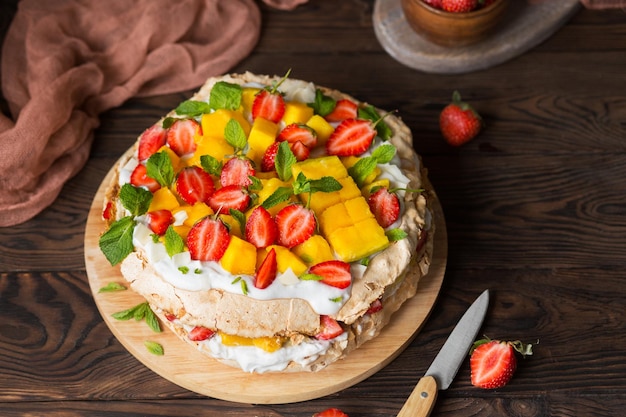 딸기 망고와 코코넛 크림을 곁들인 파블로바 뉴질랜드 음식 열대 케이크 이국적인 디저트