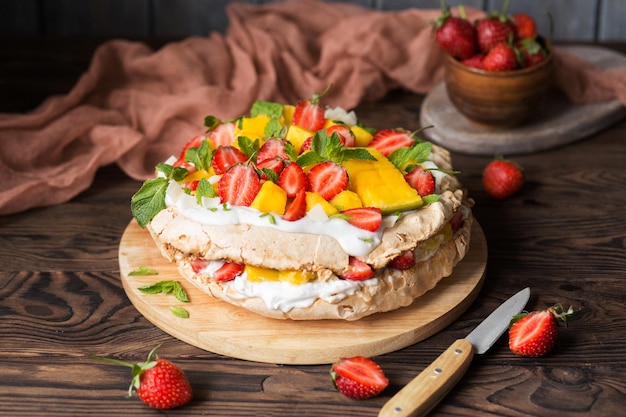 Pavlova with strawberries mango and coconut cream New Zealand food Tropical cake Exotic dessert