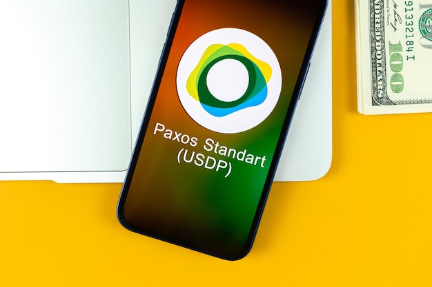 Paxos Standart USDP muntsymbool. Handel met cryptocurrency, digitaal en virtueel geld, bankieren met concept voor mobiele telefoons. Zakelijke werkruimte, tafel met laptop bovenaanzicht foto