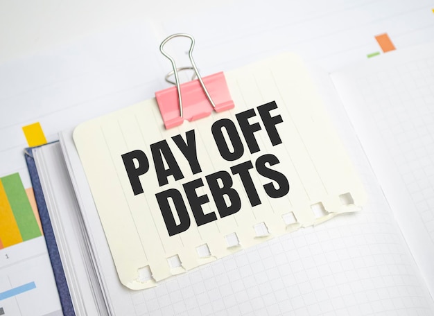 Pay off debts words on yellow sticker and charts