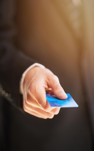 Paying by card Cropped shot of a businessman holding out a credit card as payment