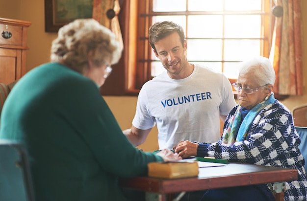 Foto paying it forward inquadratura di un volontario che lavora con gli anziani in una casa di riposo