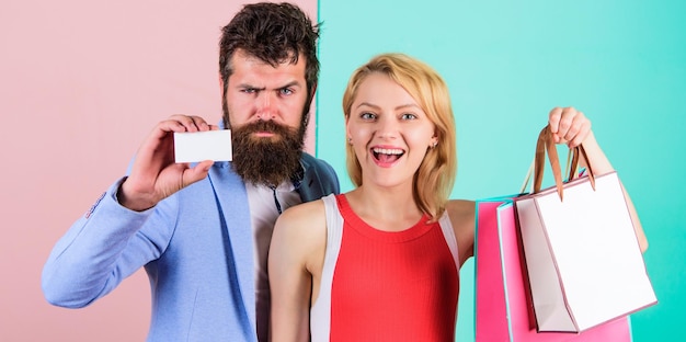 Paying while dating couple with luxury bags in shopping mall\
couple enjoy shopping man bearded hipster hold credit card and girl\
enjoy shopping ask man to purchase lots presents for\
girlfriend