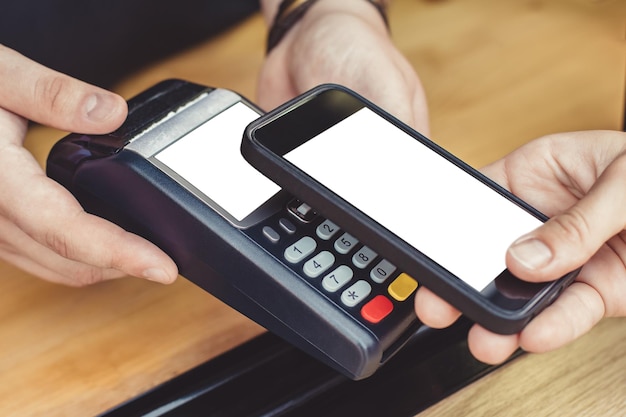 Pagamento per un acquisto tramite smartphone tramite un terminale di pagamento in un caffè all'aperto