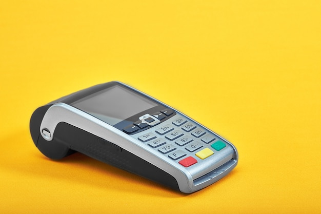 Photo payment terminal, compact pos terminal on yellow background