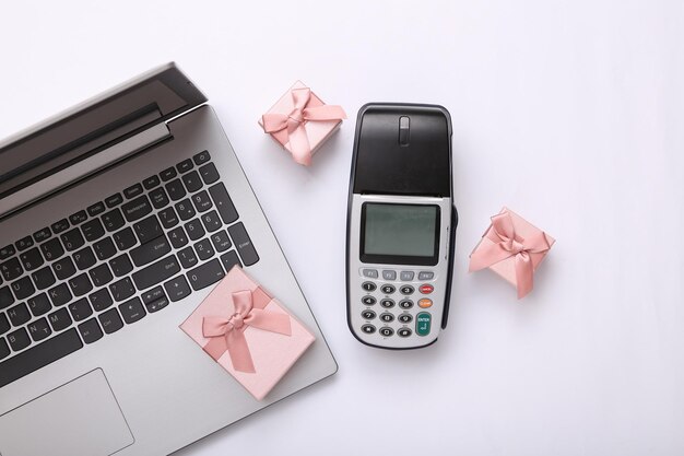 Payment terminal laptop and gift boxes on white background