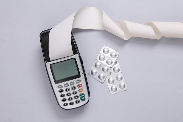 Payment terminal and pills with on gray background