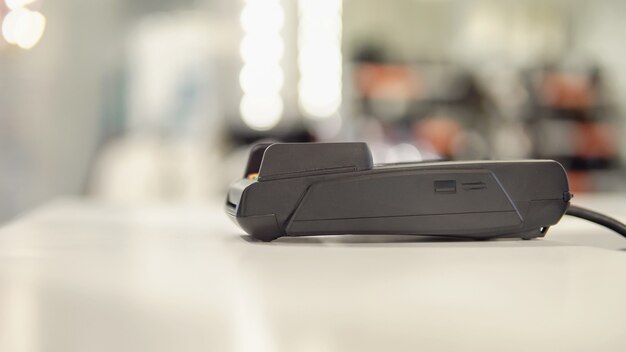 Payment terminal on the table on blurred shop background.