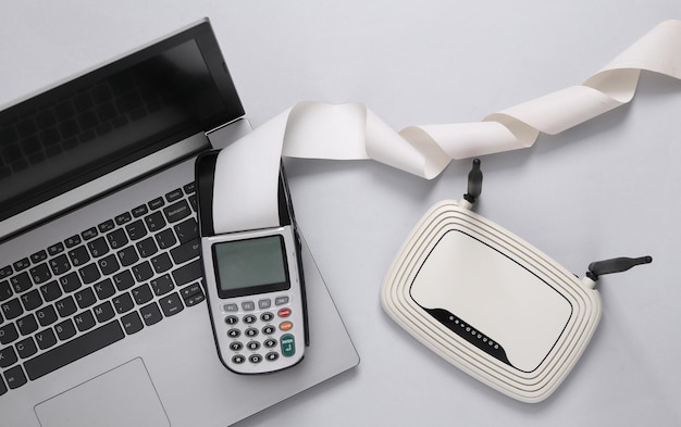 Payment terminal and wifi router laptop on a gray background