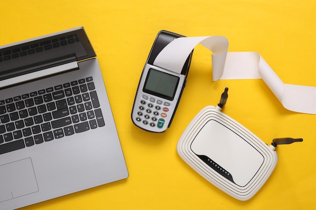 Payment terminal and wifi router laptop on yellow background