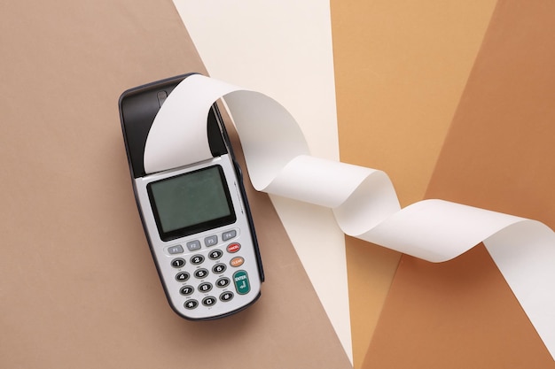 Payment terminal with paper tape on colored background