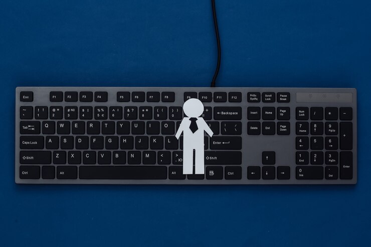 Photo pc keyboard and paper businessman figurine on a classic blue