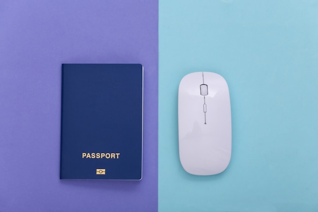 Mouse per pc con passaporto su sfondo blu pastello viola. concetto di viaggio. vista dall'alto