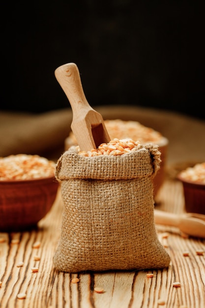 Pea groats in bowls and bags on a wooden background High quality photo