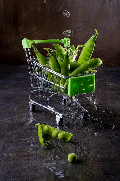 Pea pods on a brown background with spray and splash of
water.