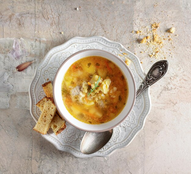 Pea soup with croutons in a white vintage bowl on a beige background