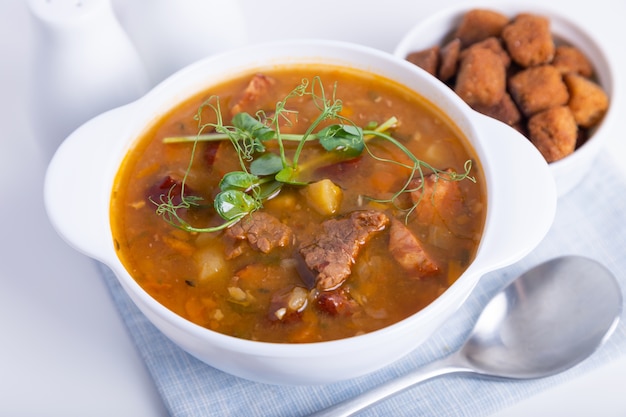 Photo pea soup with meat and smoked sausages