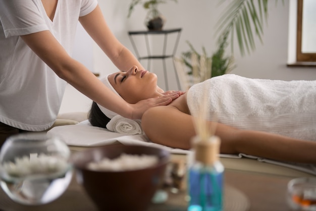 Peace and calmness. Pleasant calm woman closing her eyes and relaxing during the massage