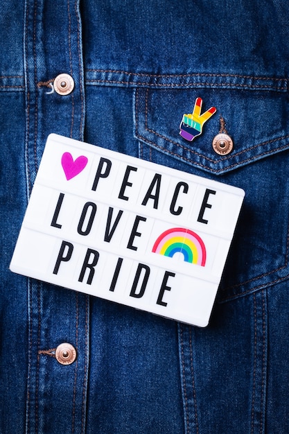 Pace amore orgoglio testo bandiera lgbtq arcobaleno su sfondo denim