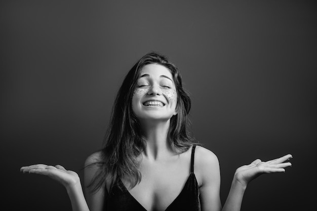Peace of mind Youth optimism Young woman with toothy smile and closed eyes Black and white portrait