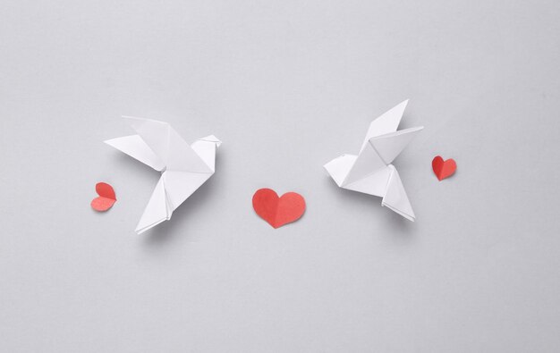 Peace symbol Origami doves birds and paper cut hearts on gray background