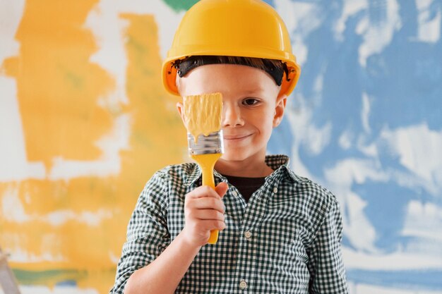 Peace in ukraine blue and yellow colors little boy painting\
walls in the domestic room