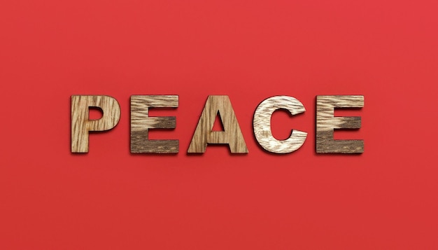 Photo peace word written in colorful wooden alphabet letters on red background the concept of a terrible war destroying country top view copy space