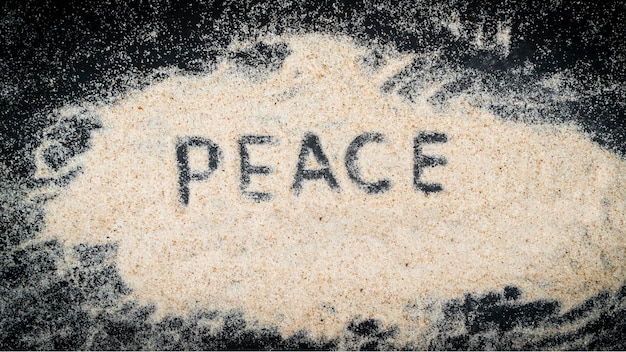 PEACE word written on white sand