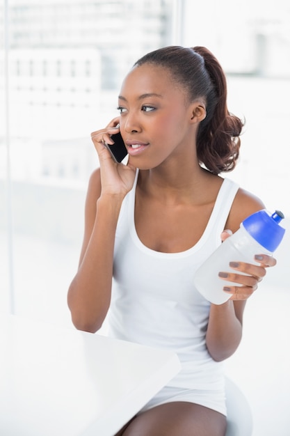 Tranquilla donna atletica al telefono