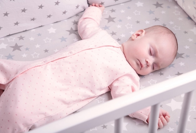 Peaceful baby lying on a bed while sleeping, top view