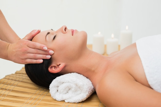 peaceful brunette enjoying a facial massage