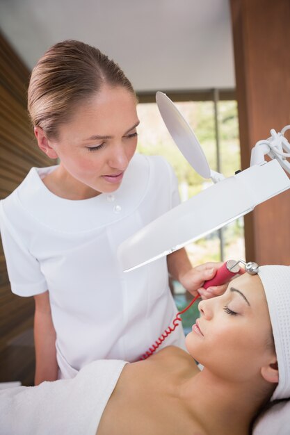 Photo peaceful brunette getting micro dermabrasion from beauty therapist