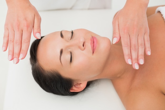 Peaceful brunette getting reiki therapy