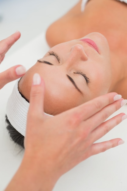 Peaceful brunette getting reiki therapy