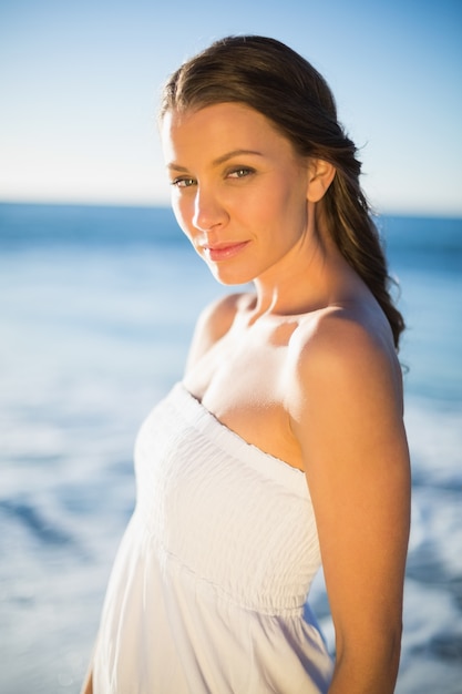 Peaceful brunette in white summer dress posing